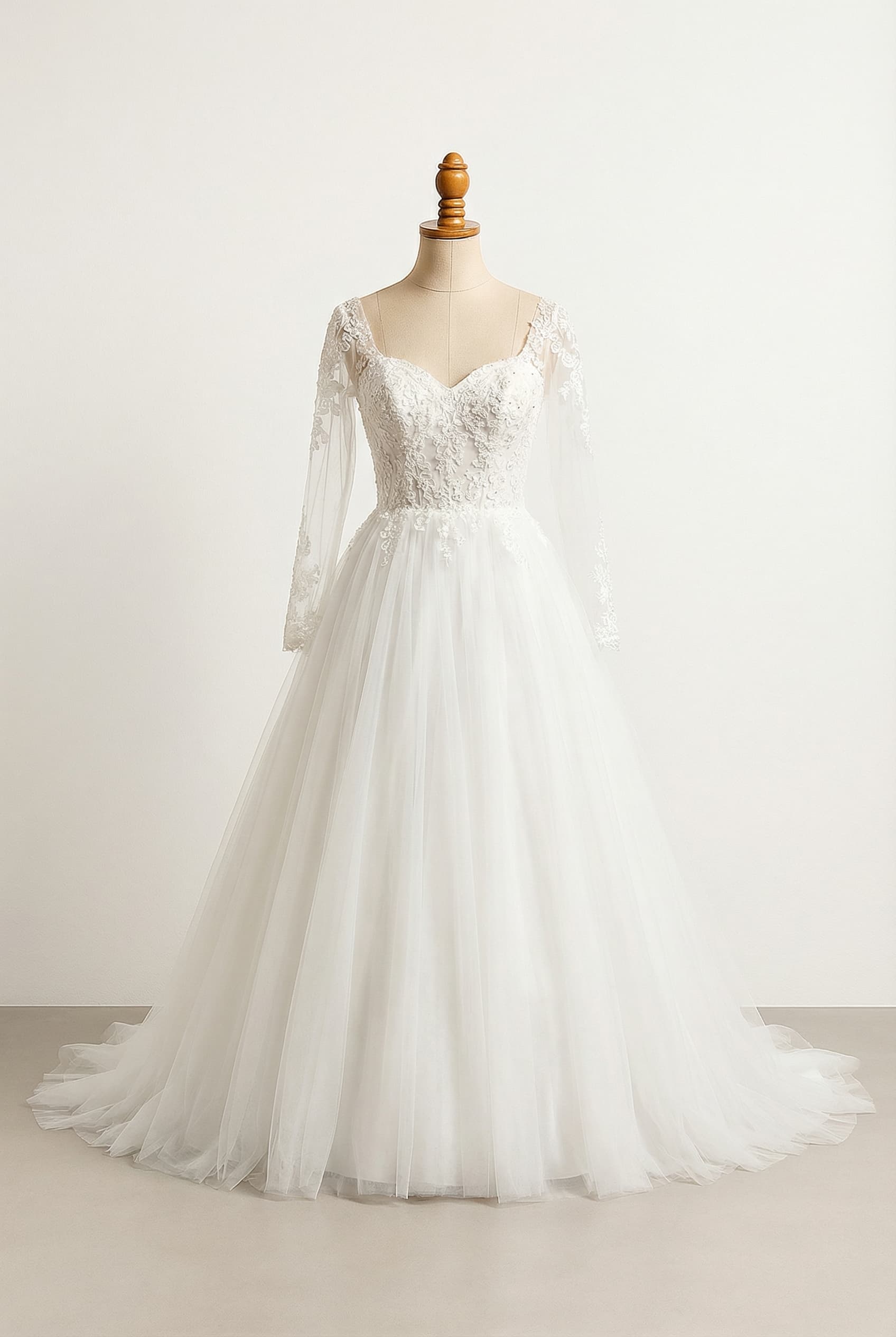 A romantic white floor-length ball gown wedding dress with a sweetheart neckline, elegant long sleeves, and delicate lace and floral appliques on the bodice and sleeves, crafted from flowing tulle.