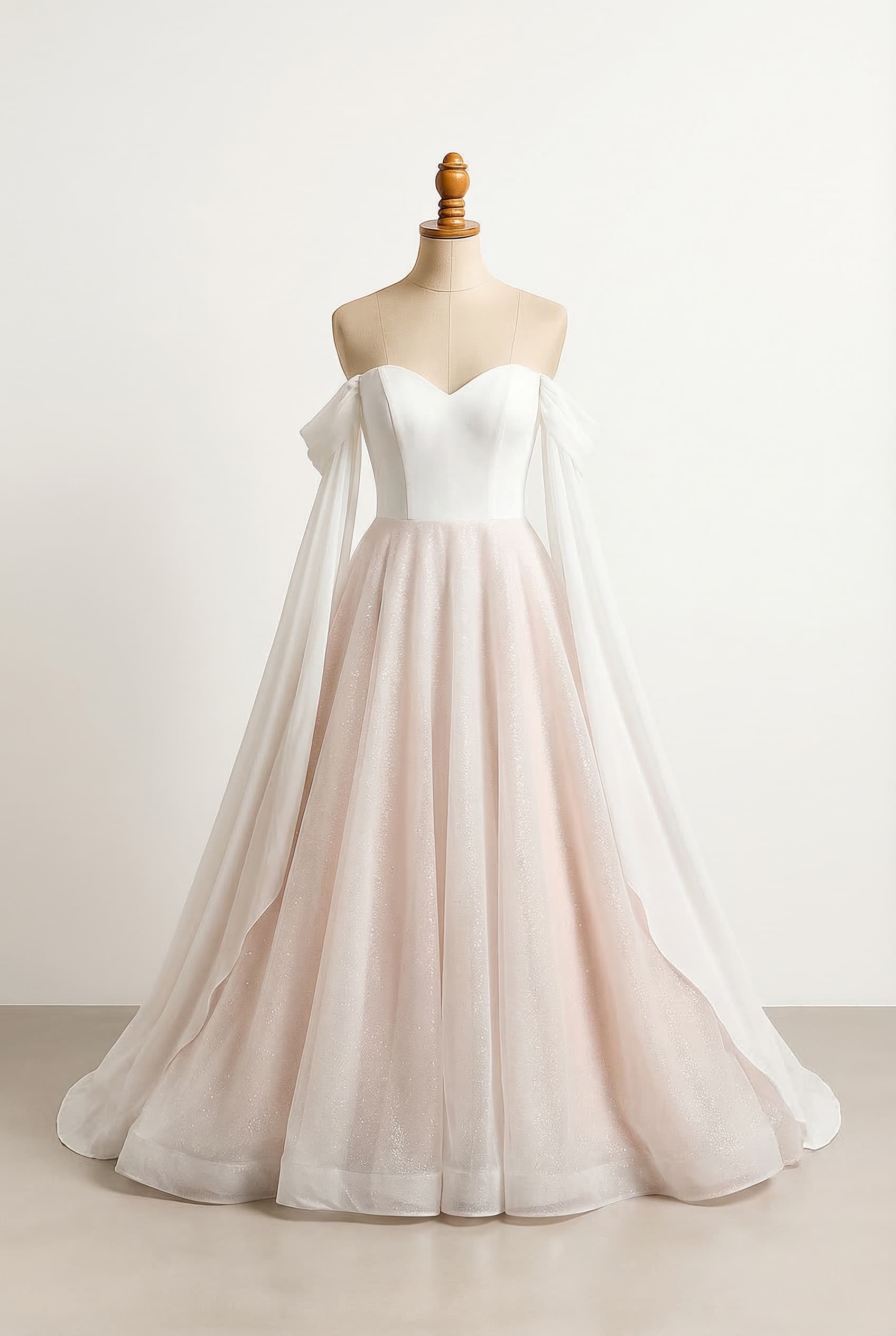 White dress with a hint of blush in the skirt Full skirt floor length with a glitter layer Sweetheart neckline and off shoulder sleeves that drape from the elbow in the front to floor length in a nice cascade in chiffon kind of fabric Bodice princess seams Chiffon sleeves to floor length cascading down and a sweetheart bodice and glitter in the skirt