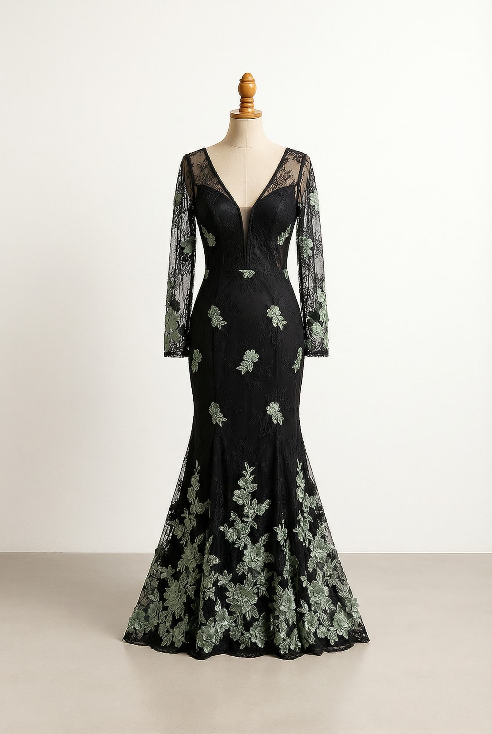 A romantic black fitted lace wedding dress with elegant sage green lace flowers, scattered and then more at the bottom.