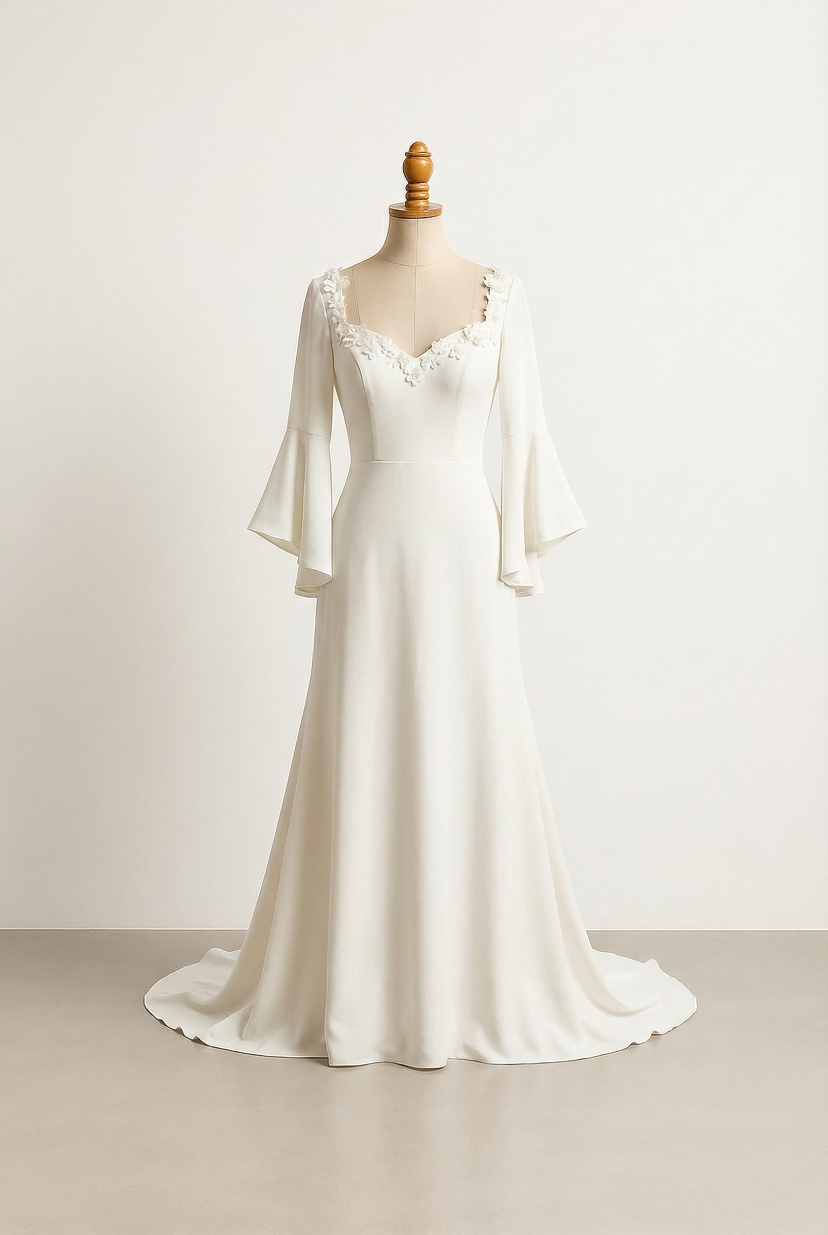 A romantic wedding dress with elegant details, smooth and fitted, with flowers along the sweetheart neckline, and bell sleeves.