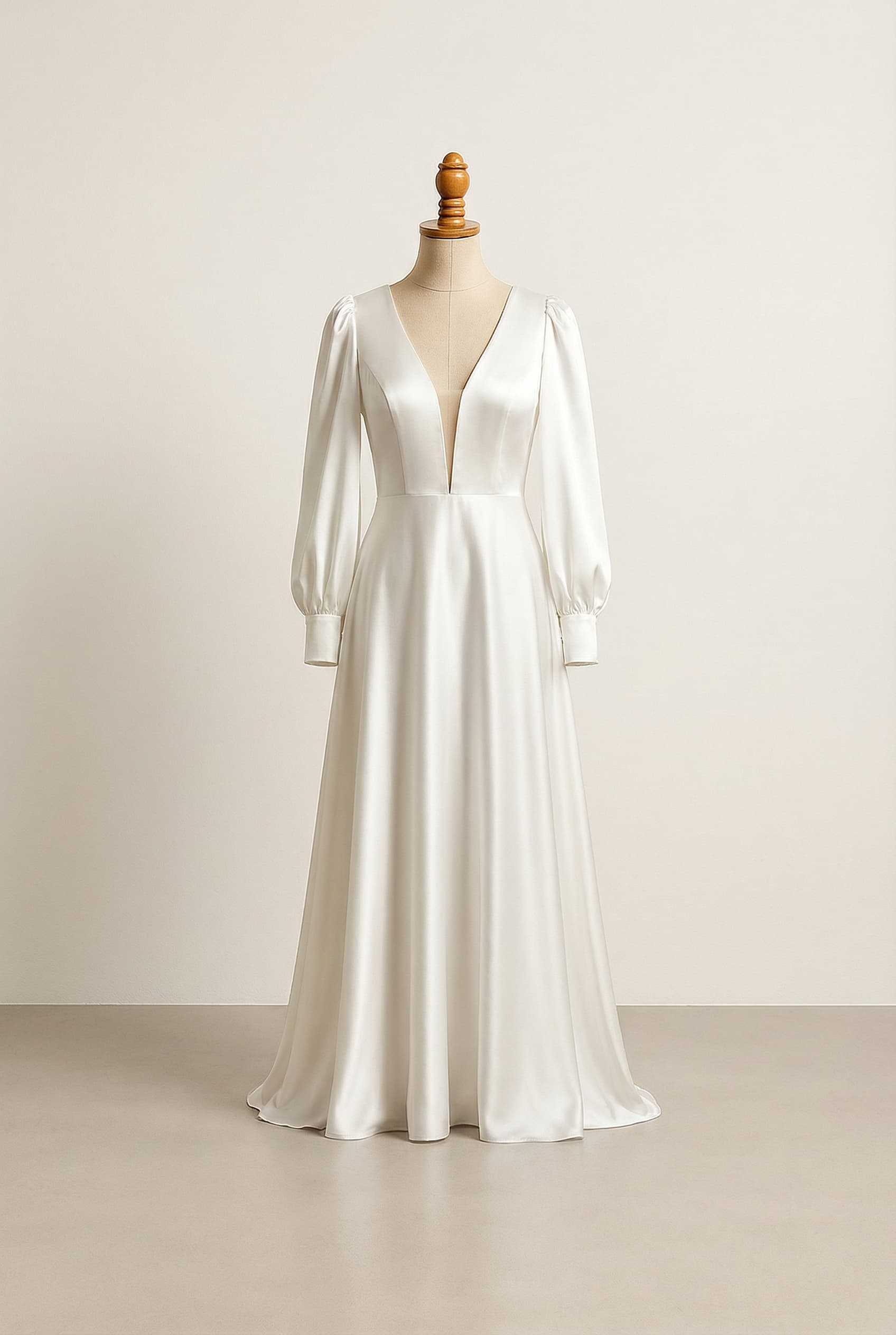 A romantic wedding dress with elegant details, featuring long puffy sleeves cuffed at the wrist, a plunge neckline, and a deep open back.