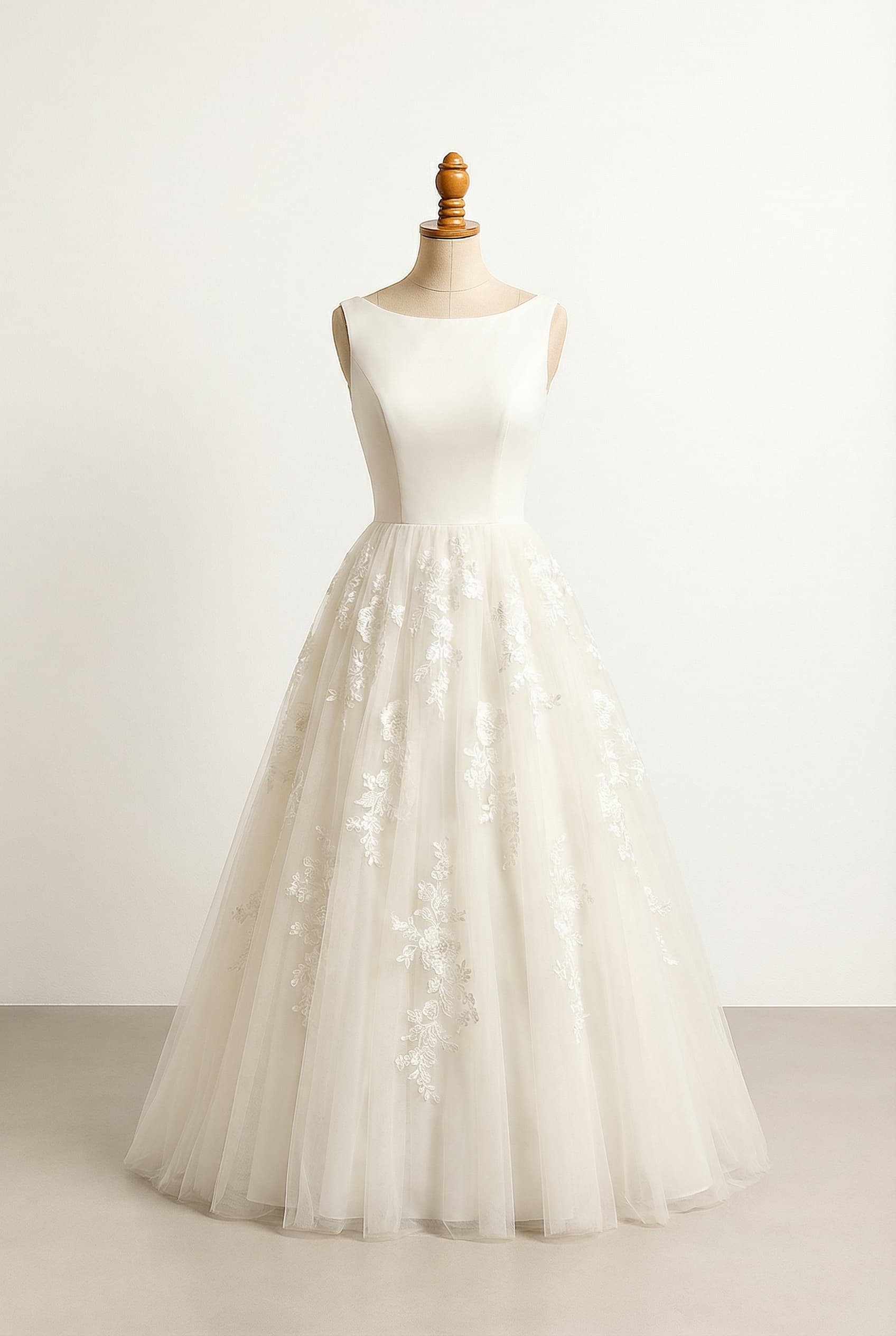 A romantic wedding dress with elegant details, featuring floral lace on the bodice and a voluminous tulle skirt with floral lace.