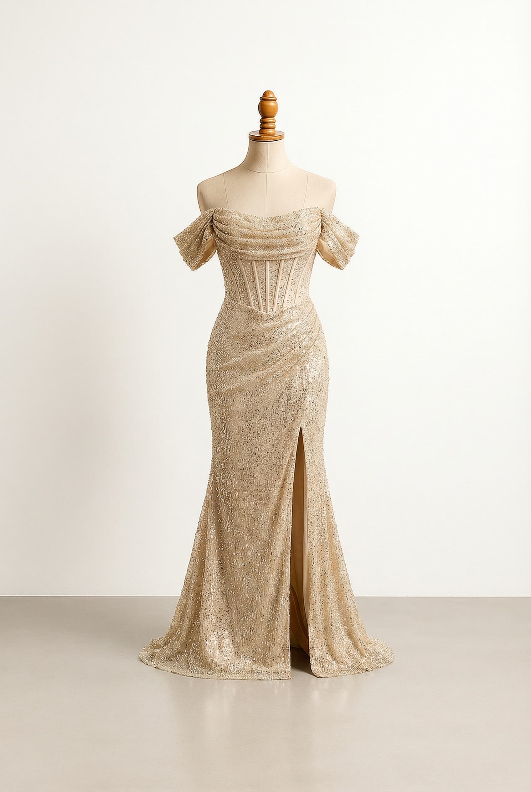 Gold, sparkly prom dress with a corset top, a slit, and a flowy bottom.