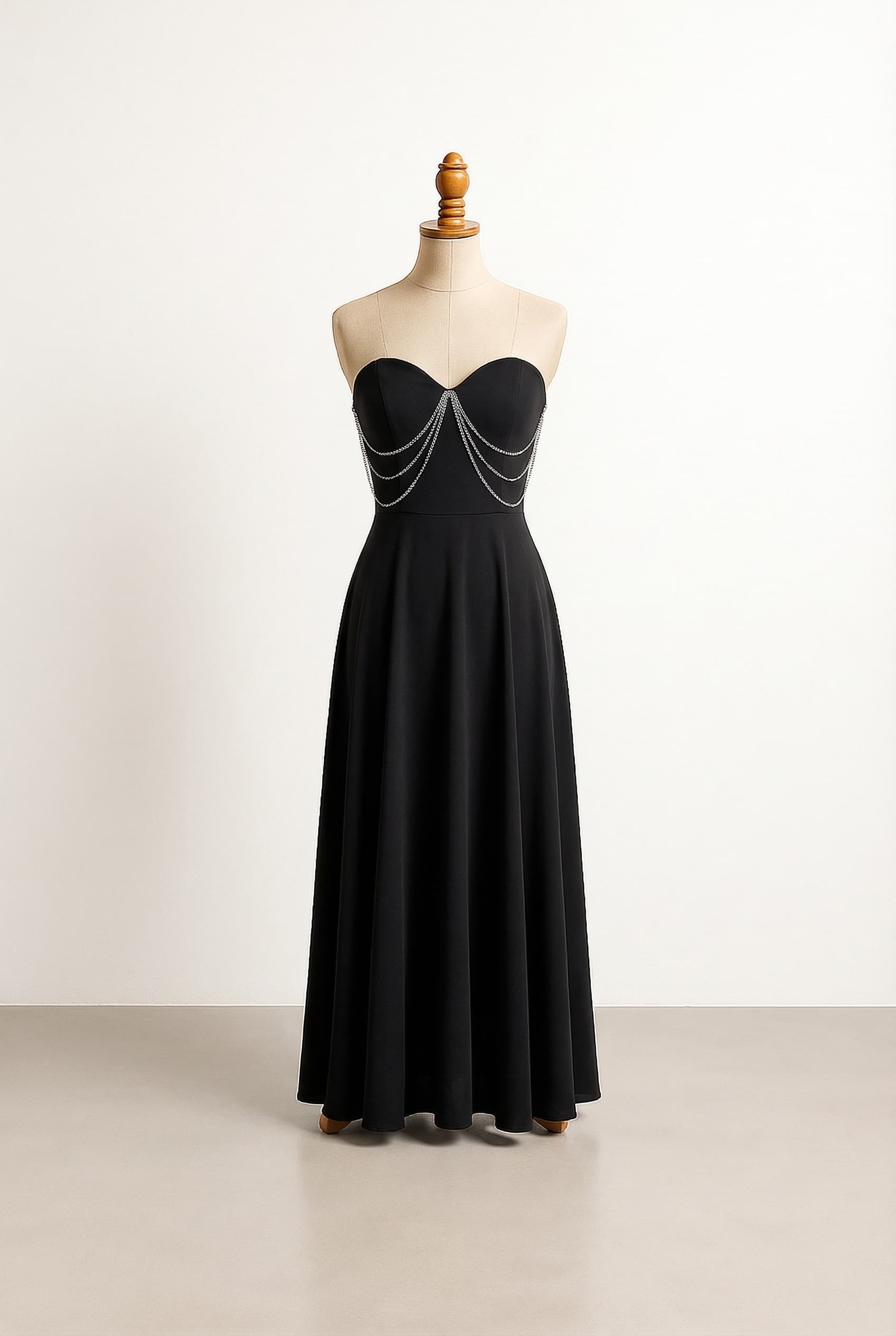 All black dress fitted at the waist and flowy at the bottom with a few silver chains on the front, floor length, Sweetheart - Heart-shaped curved neckline