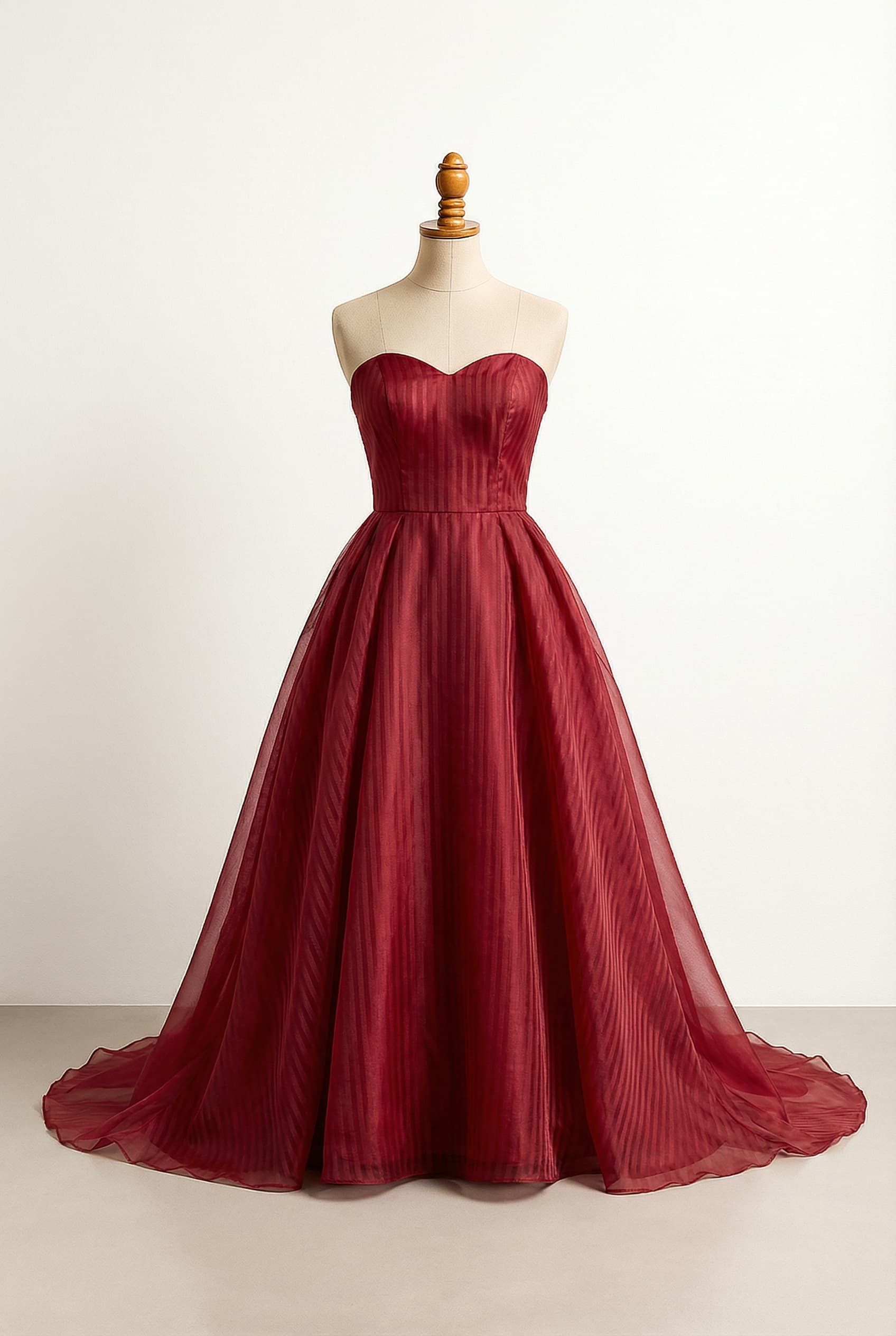 I want a balanced custom dress that is a deep red color. احمر; preset_type: Custom; modestyPreference: balanced; color: deep red; length: Chapel - Slight train (1-2 feet past feet); sleeve: Sleeveless - No sleeves; neckline: Sweetheart - Heart-shaped curved neckline; silhouette: Ball Gown / Princess - Fitted bodice with a full, voluminous skirt; fabric: Organza - Sheer, crisp fabric often used for full skirts and overlays. The fabric has vertical stripes.
