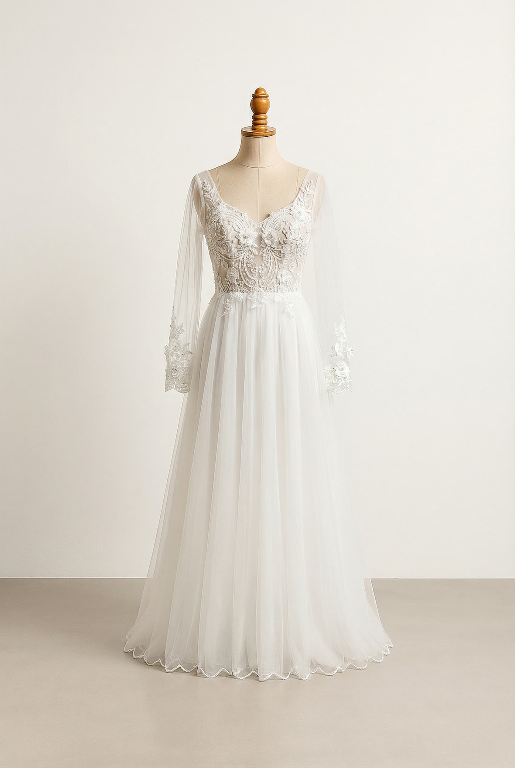 Bodice with floral beaded embroidery and lace design; A-Line silhouette, full but not overly voluminous; Long tulle sleeves with a fitted wrist