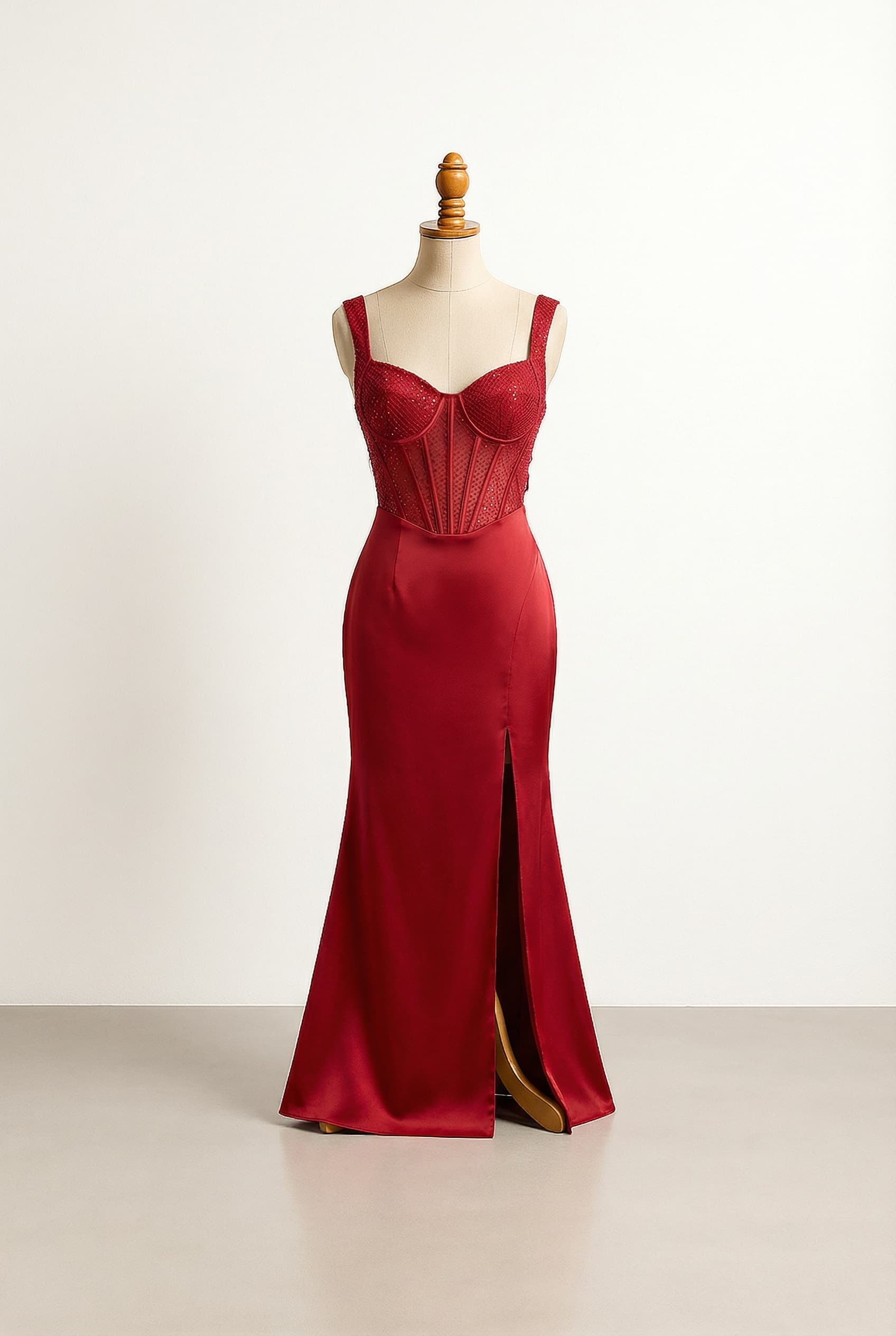 a carmine red prom dress, sweetheart neckline, subtle sequins around bust, carmine net corset bodice, sleeveless, flowing carmine satin mermaid skirt with a mid-thigh slit on the left and half way on thigh, ribbon back