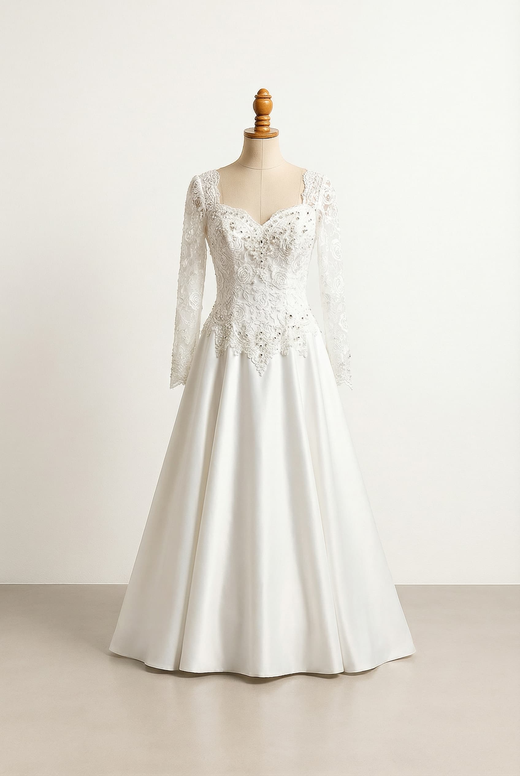 A romantic wedding dress with elegant details, featuring a white, floor-length A-line gown with a sweetheart neckline, an exquisite lace rose bodice adorned with crystals, pearls, and sequins that peaks past the natural waist, elegant long lace sleeves, and a beautiful satin skirt.