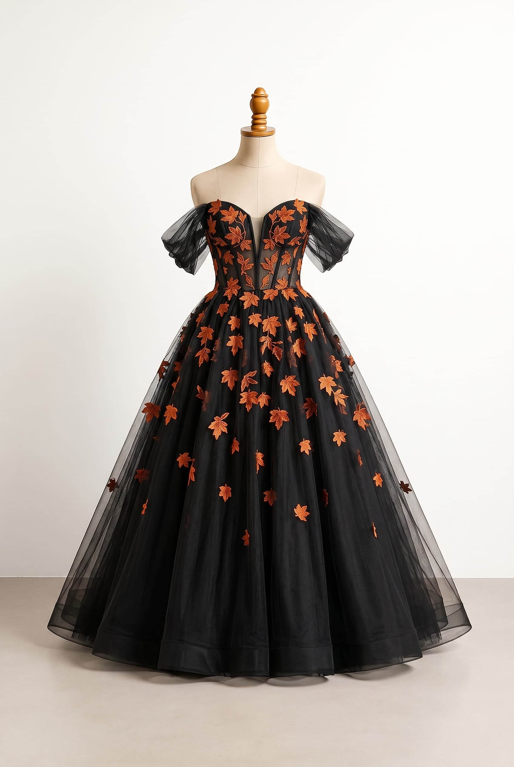 Balanced wedding dress, black with orange fall leaf appliques all over the bodice and skirt, scattered with increasing airiness as they descend the skirt, corset top with a plunging sweetheart neckline, strapless with winged dropped sleeves on the upper arm, very full ballroom skirt, matte finish