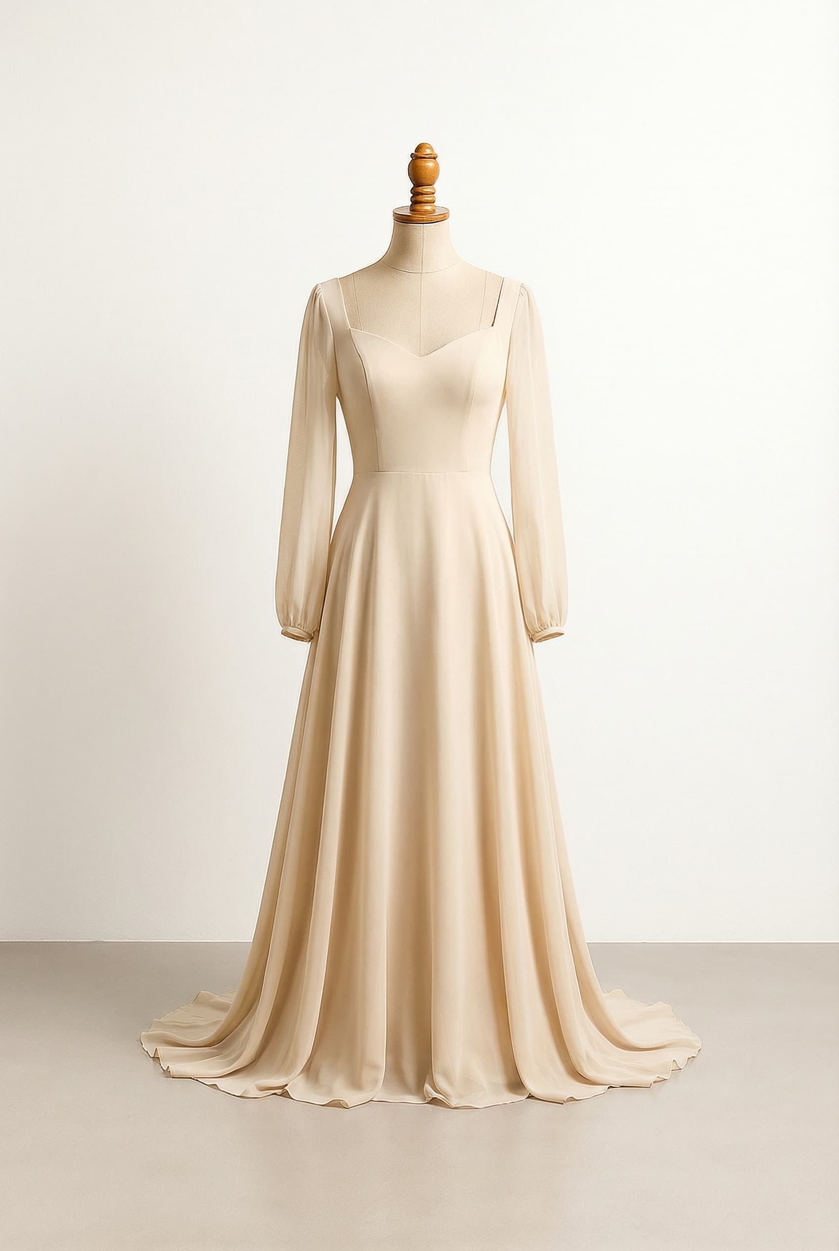 A floor-length, champagne A-line gown with a modest sweetheart neckline, sleeveless, and flowing chiffon fabric.