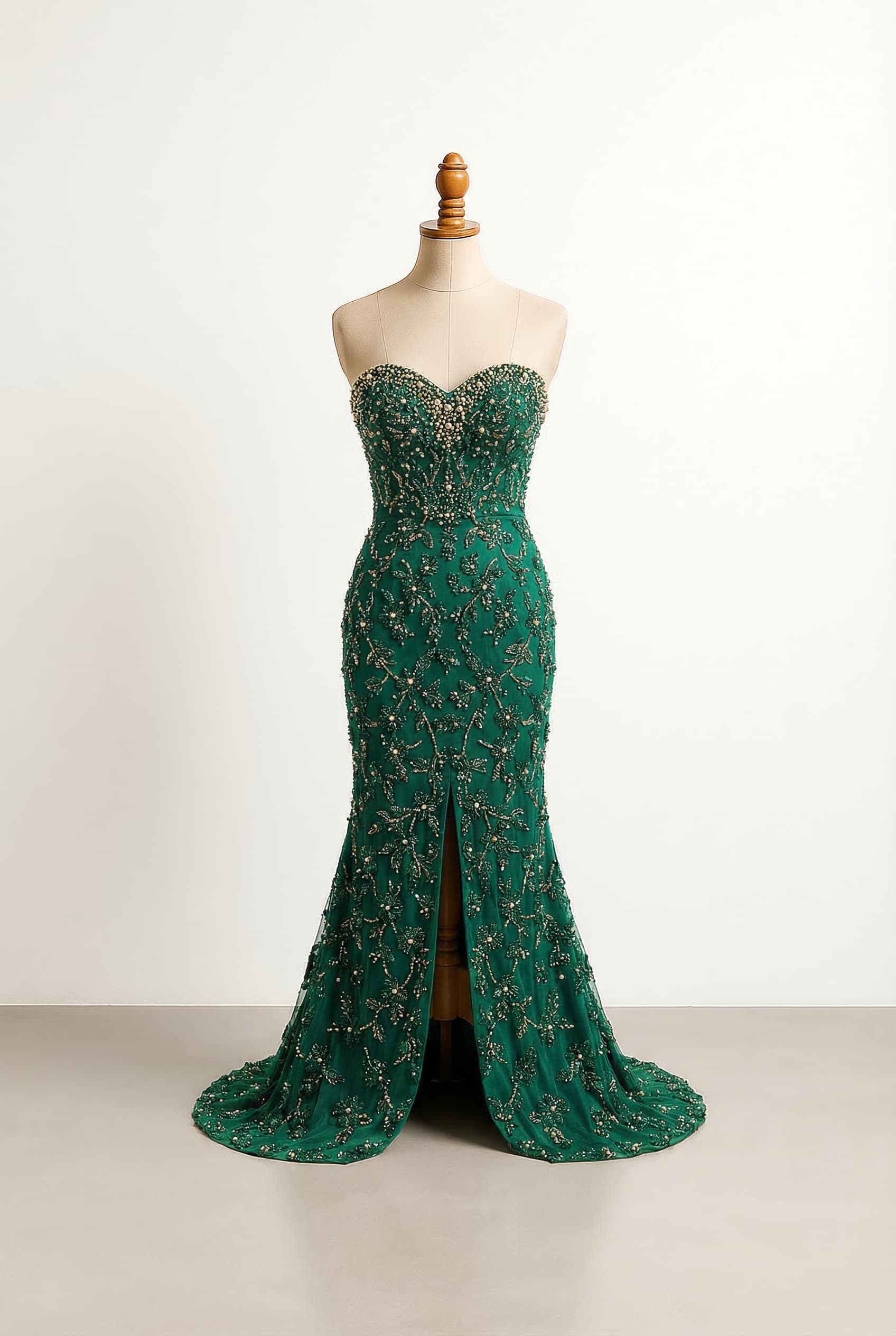 I want a balanced prom dress with no sleeves, a sweetheart neckline, and emerald green floral beading with gold accents concentrated on the chest area. The mermaid silhouette will be fully beaded, extending to the hem with a slit at the bottom.
