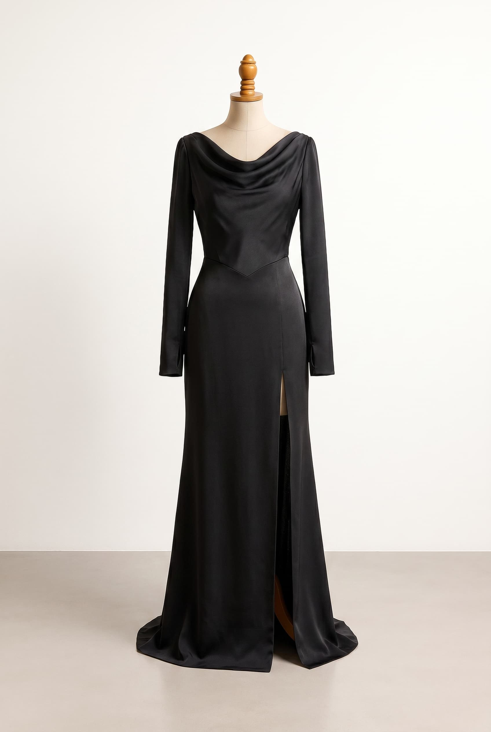 Balanced black wedding dress with V-shaped waist, leg slit, draped off-shoulder neckline across chest to shoulders, fitted long sleeves with thumb slots, and open shoulder corset bodice that ends in a V, transitioning into a floor-length column gown