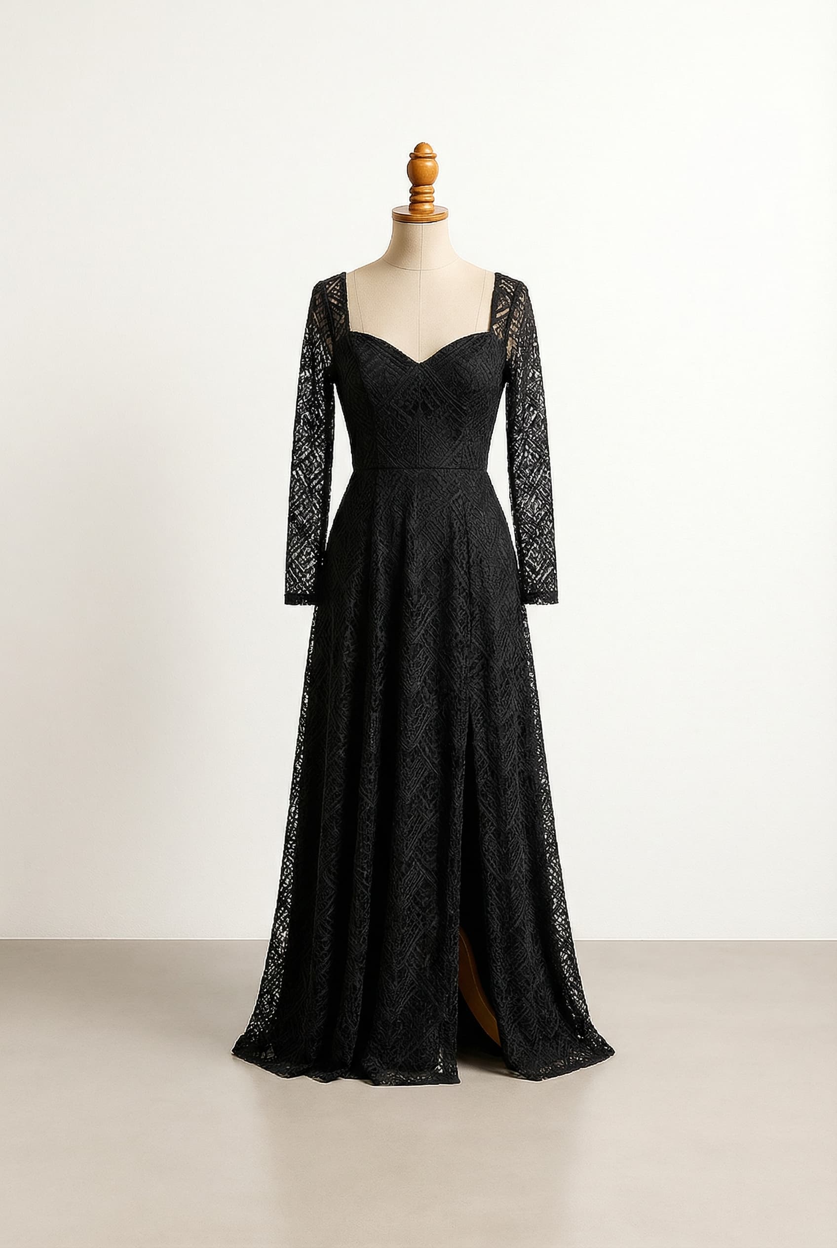 A black, floor-length dress with a sweetheart neckline, a fitted waist, a flowing skirt with a single leg slit, and beautiful long sleeves adorned with geometric lace.
