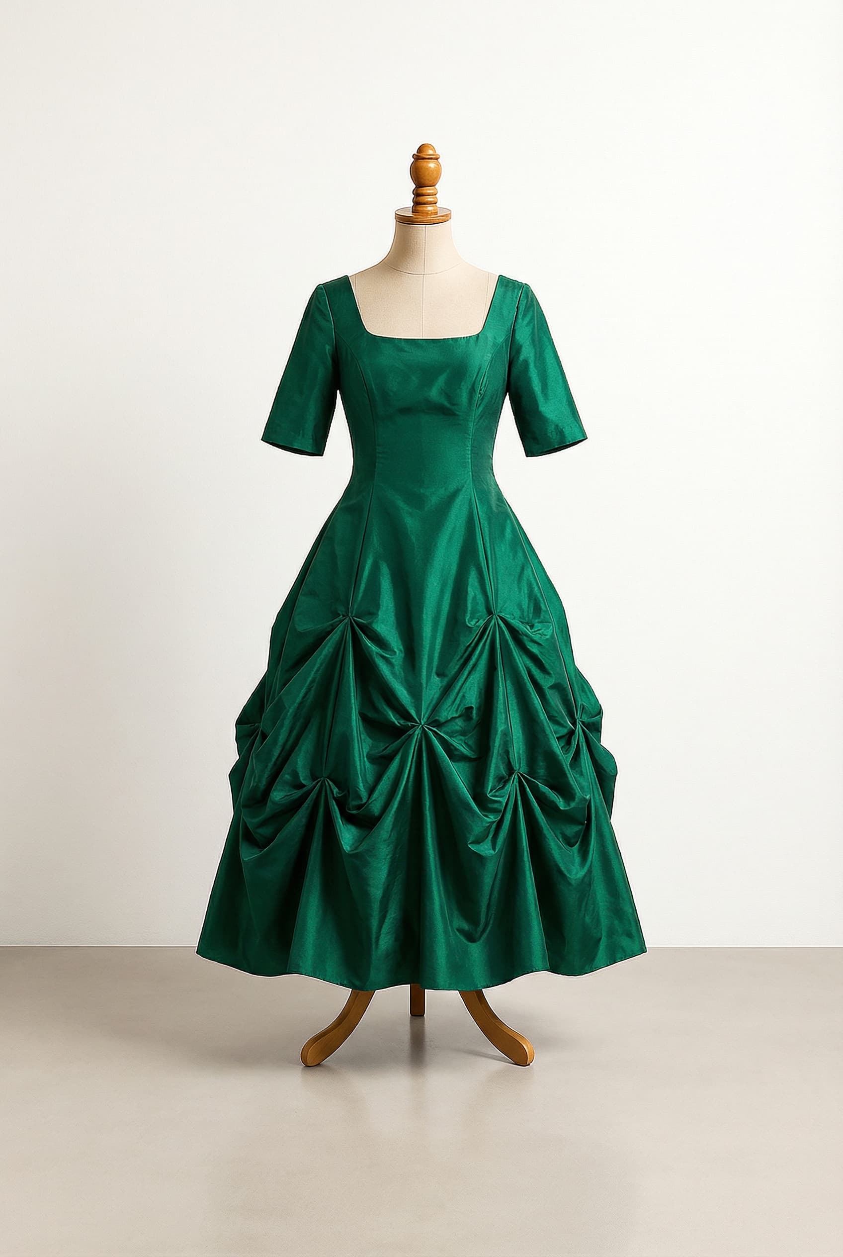 A romantic wedding dress with elegant details, featuring a tufted / bubble-tuck pick-up gown style, an A-line silhouette, a square neckline, half sleeves, an emerald green color, an ankle length, and a taffeta fabric.