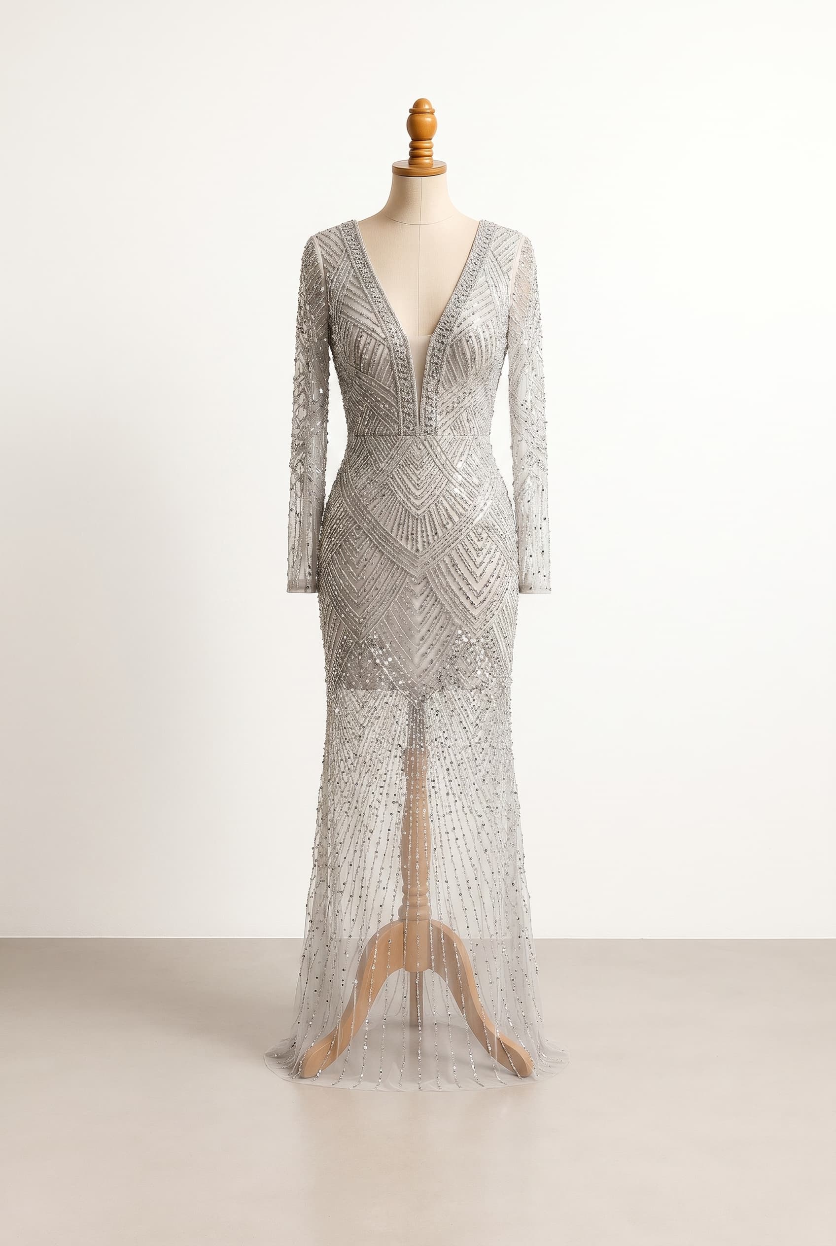 I want a revealing formal dress in Moonlight Silver, floor length, long sleeves, plunge neckline, fitted silhouette, with Moonlight silver beaded geometric embroidery fading to a sparse, sheer effect toward the hem