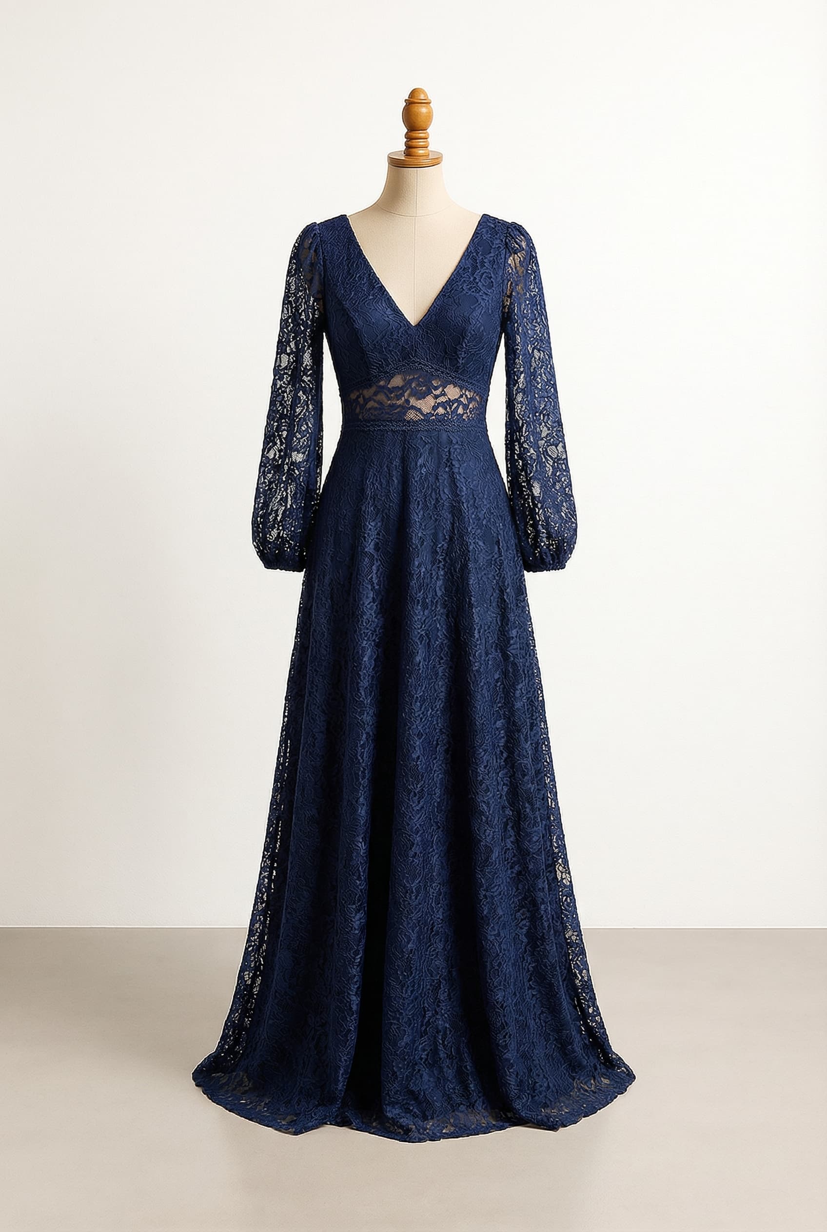 Balanced bridesmaid dress in navy blue with a deep V-neckline long puffed bishop sleeves and a natural waist The bodice is hugging the body and the skirt is A-line. Full lace overlay on the dress, with navy blue fabric underneath except for the sleeves and waistband which are lace only.