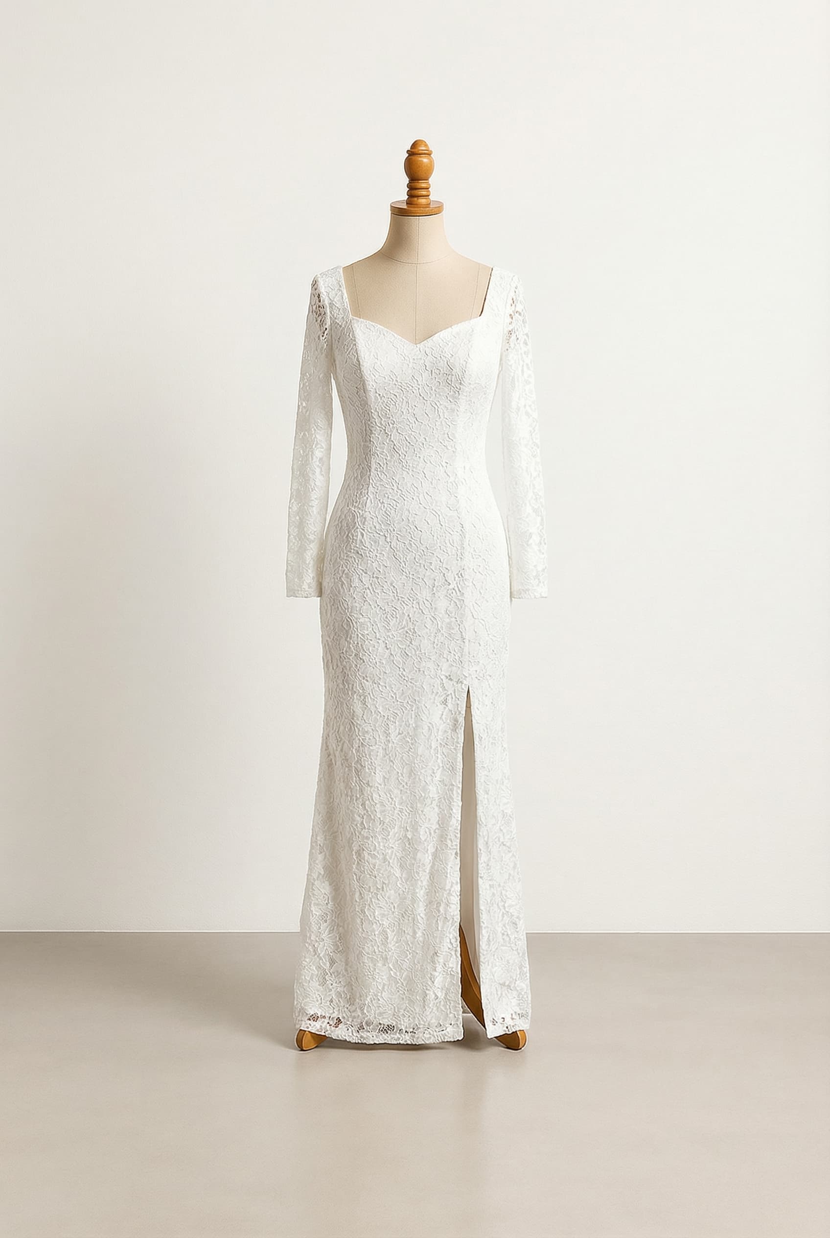 White off-the-shoulder sweetheart neckline with long lace sleeves, floor-length sheath silhouette with a mid-thigh side slit, intricate lace motifs and delicate beading on the bodice.