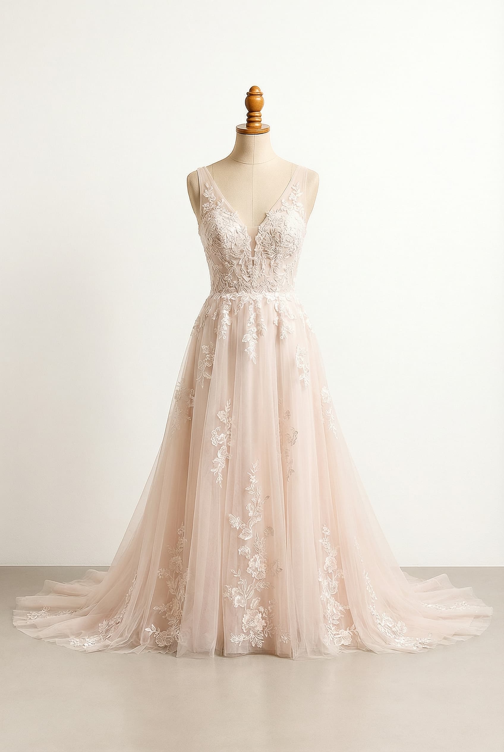 A romantic blush A-line wedding dress with elegant lace details on a sweetheart neckline, thin straps, and a cathedral train, made from lace and tulle.