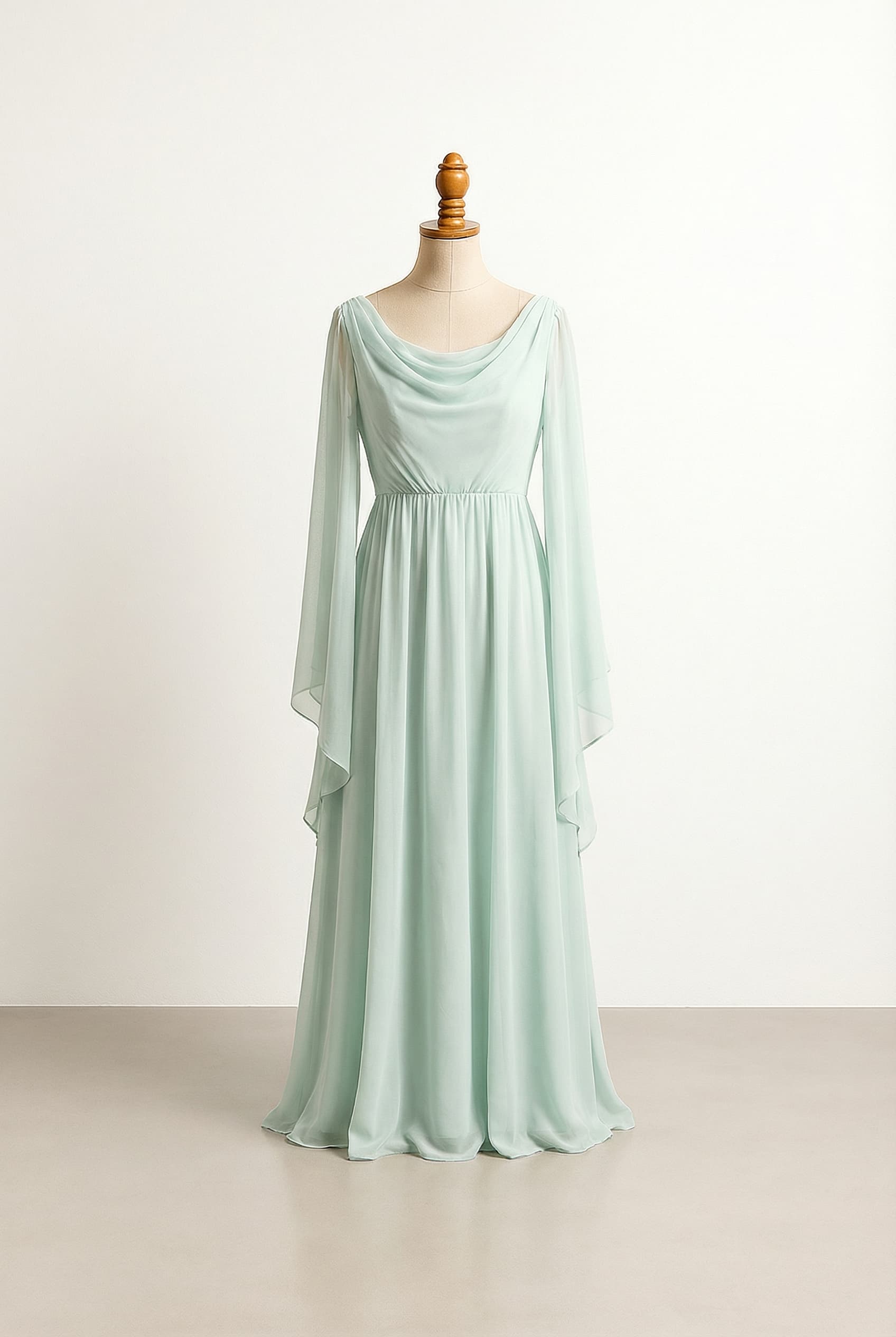 A romantic wedding dress with elegant details in a pale mint color, floor length or longer, with a Draped neckline and an Empire silhouette, inspired by Grecian styles, featuring long flowy sleeves, crafted from a light and airy fabric, and a subtle open back design with delicate crisscross straps.