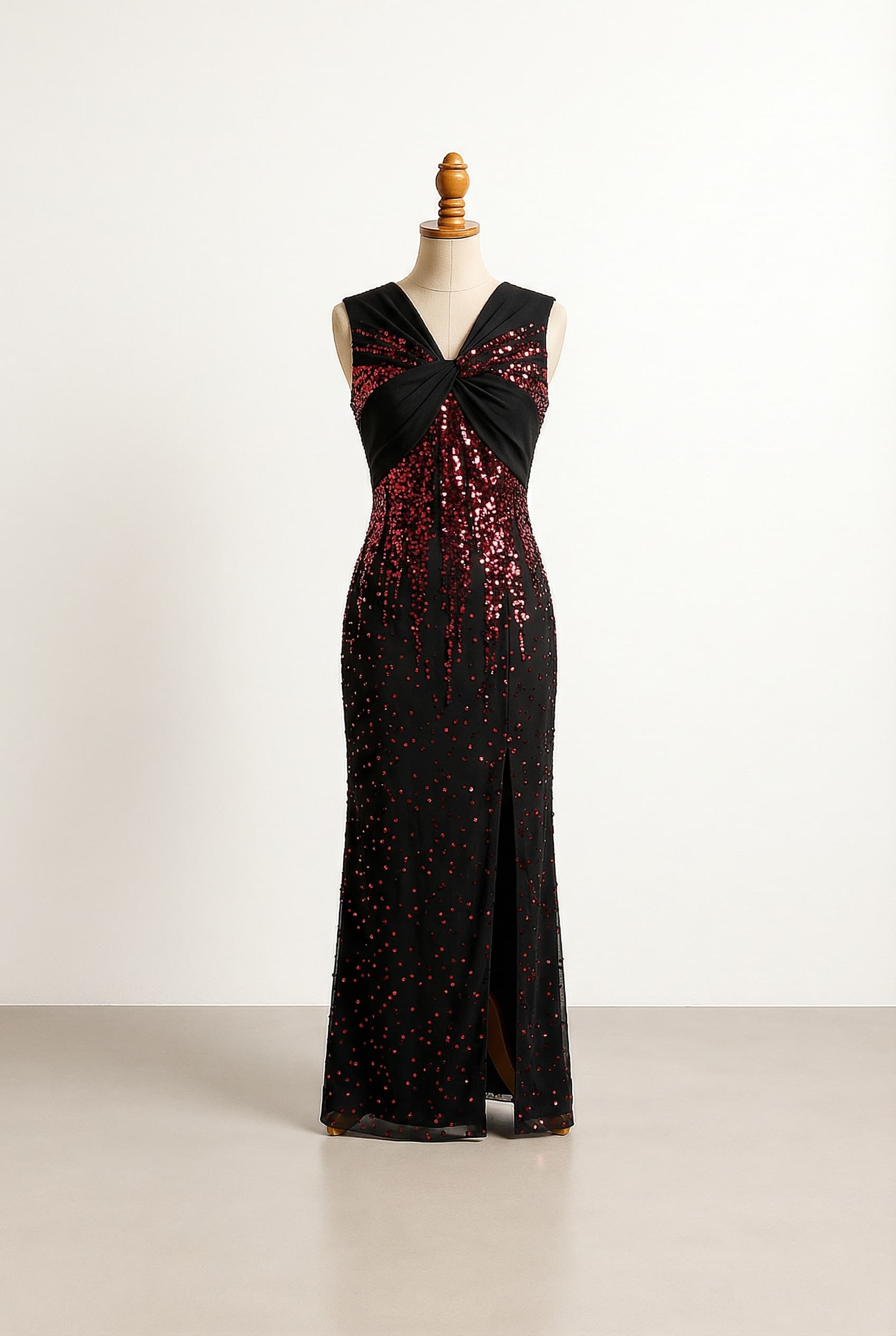 Glamorous black prom dress with red sequin embellishment, a sleeveless bodice crossed like a bow, and a straight floor-length silhouette with an open split.