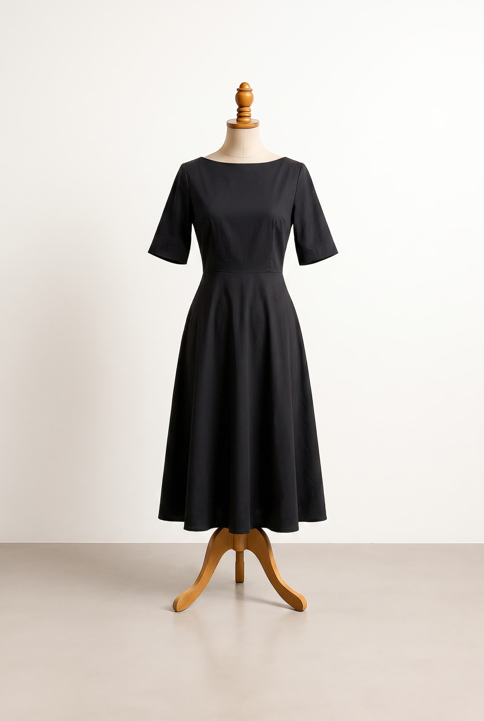 I want a modest black dress that is knee length classy and comfortable in 100 cotton with a boat neckline elbow length sleeves and a cinched waist with a flat falling skirt and no pockets