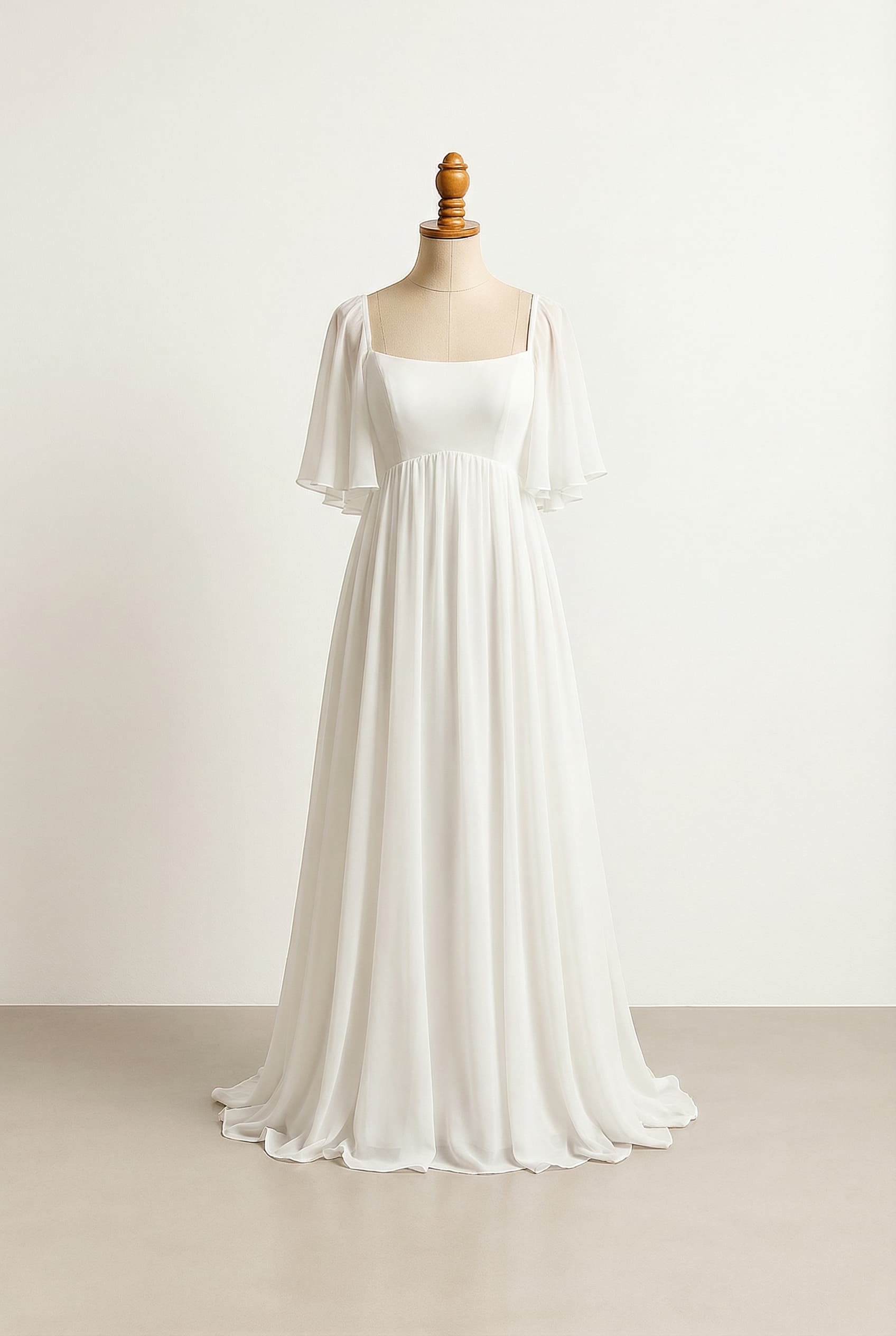 A romantic white floor-length chiffon wedding dress with an empire waist, a round neckline, elbow-length butterfly sleeves, and a bodice adorned with subtle beading. It should also have full back coverage.