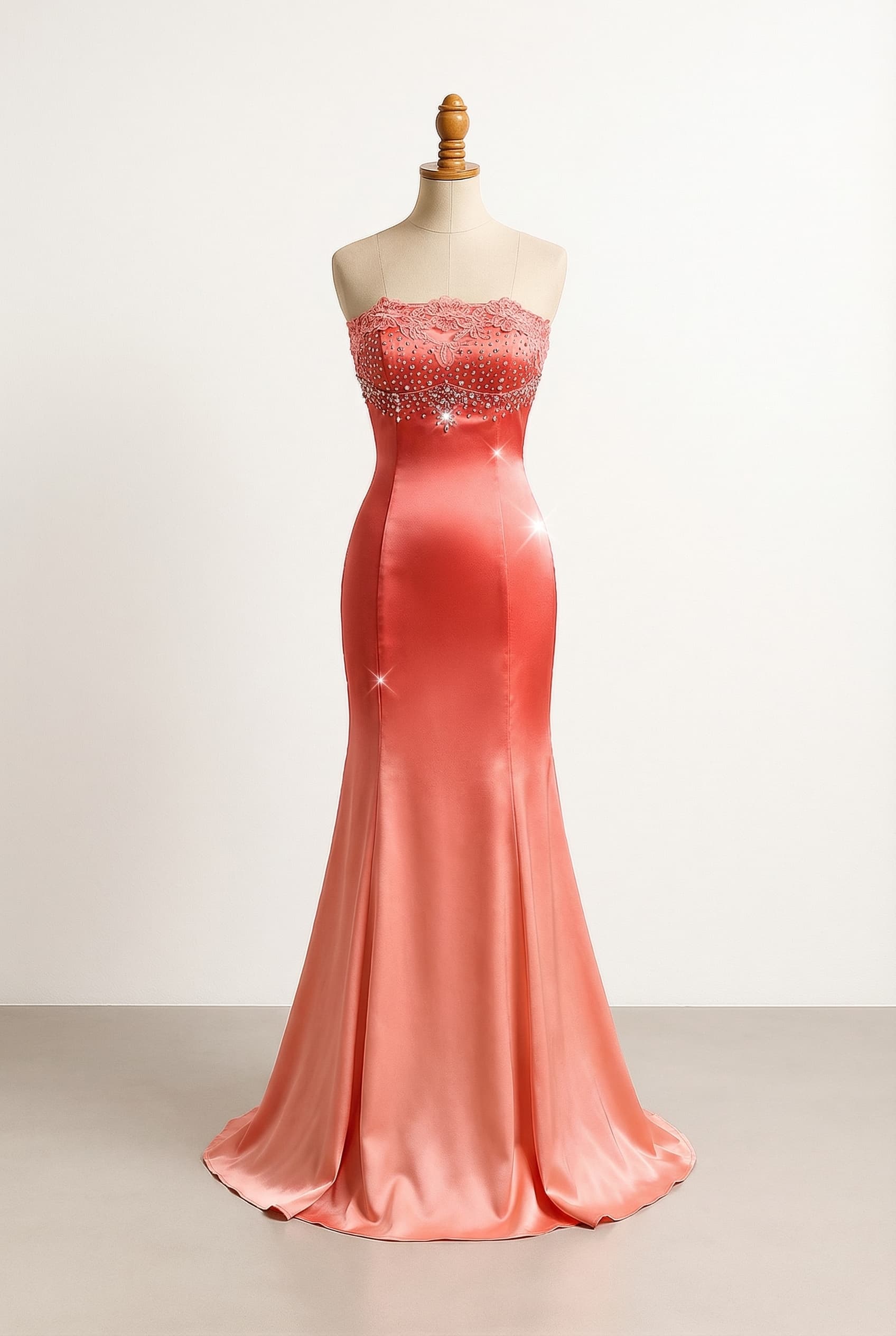 Sexy coral prom dress with scattered badazzle around the top and one big jewel in the middle of the chest, strapless, lace along the top, silky and very tight to under the butt, then flares out a little bit in a lighter shade of coral satin with flared lace at the bottom below the hips