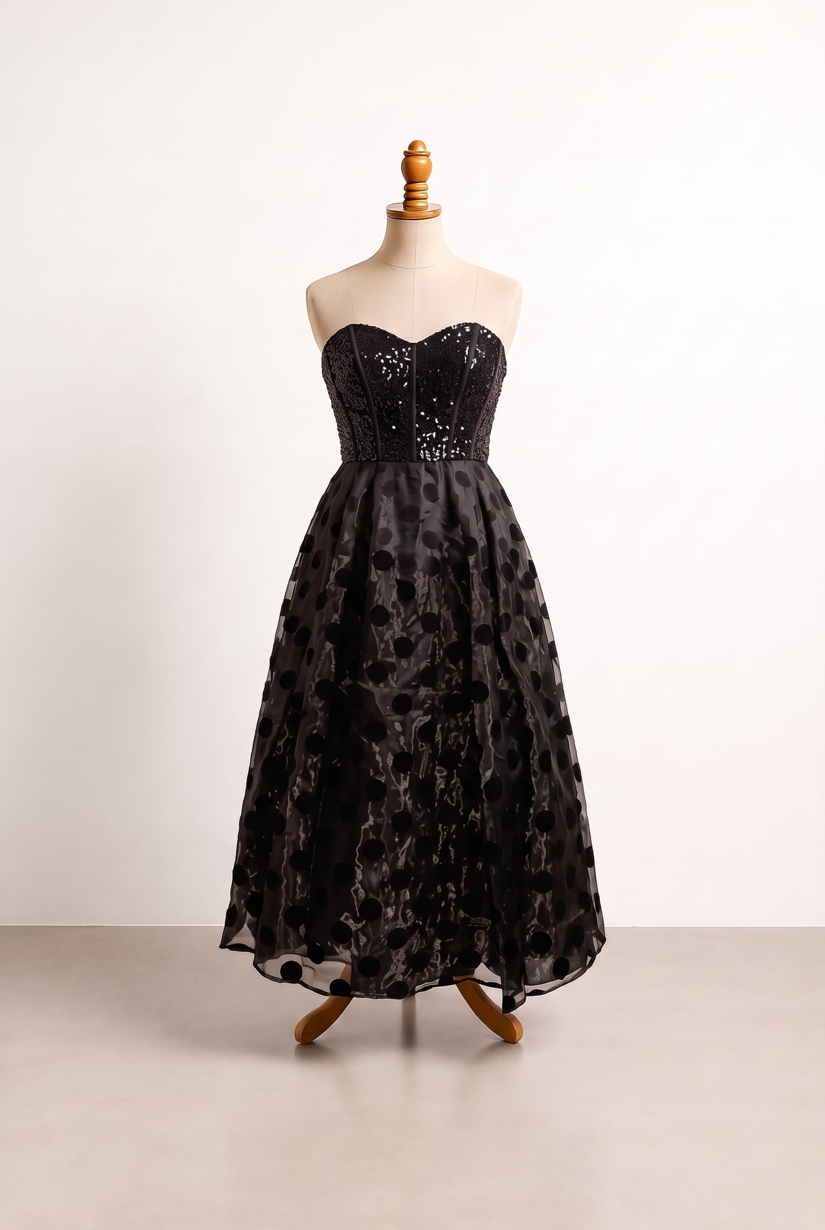 Upload dress, black, tea-length, strapless, sweetheart, natural waist, A-line, satin bodice with sheer patterned overlay skirt, seamed corset bodice, large circular skirt pattern, Add sequin or similar sparkling embellishment to the top/bodice for a Christmas party look., gold shorts, gold handbag, golden shoes, golden clutch