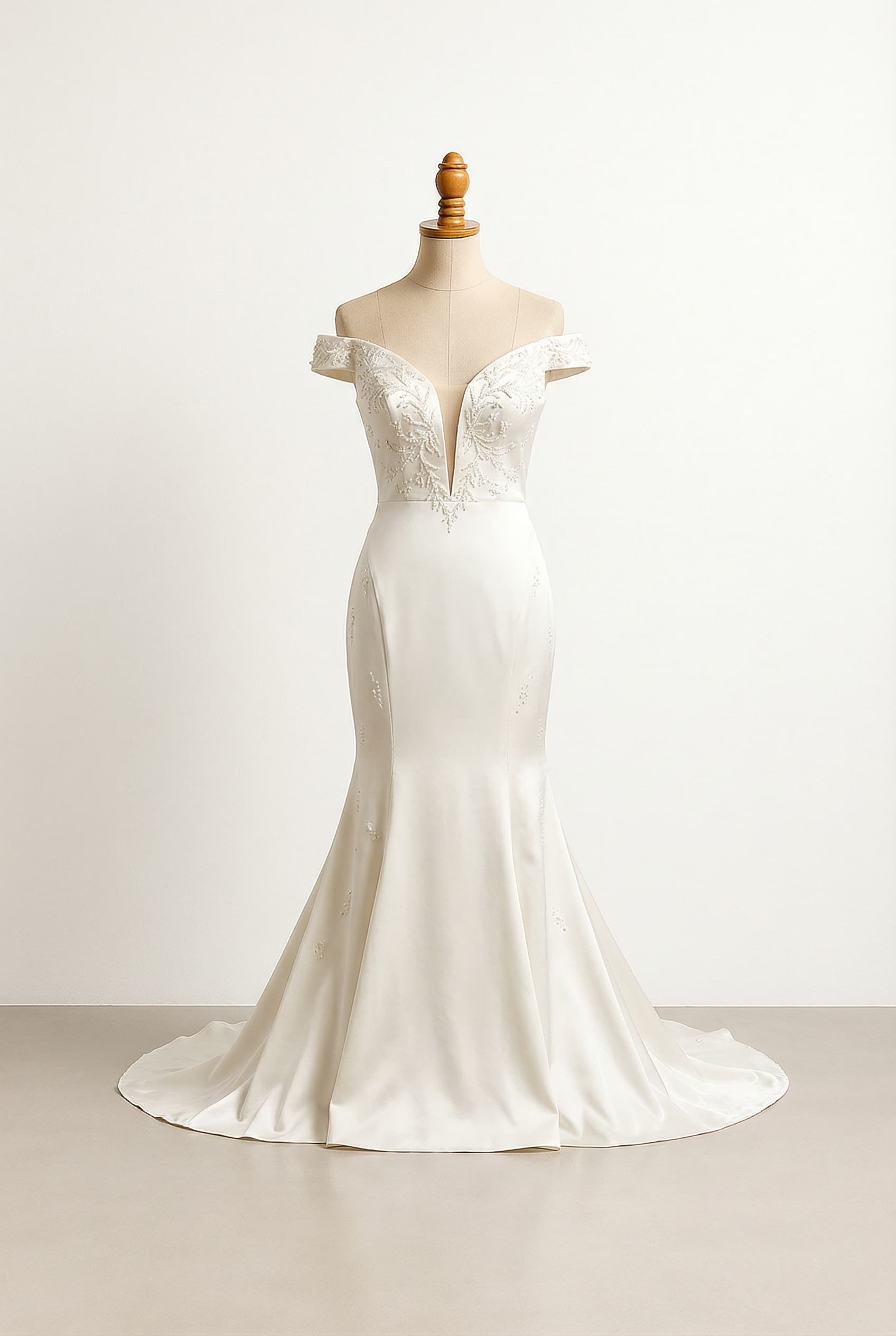 A romantic wedding dress with elegant details, featuring an off-shoulder design with a strap, a deep plunge V-neck extending to the mid-tummy, and beaded embroidery.