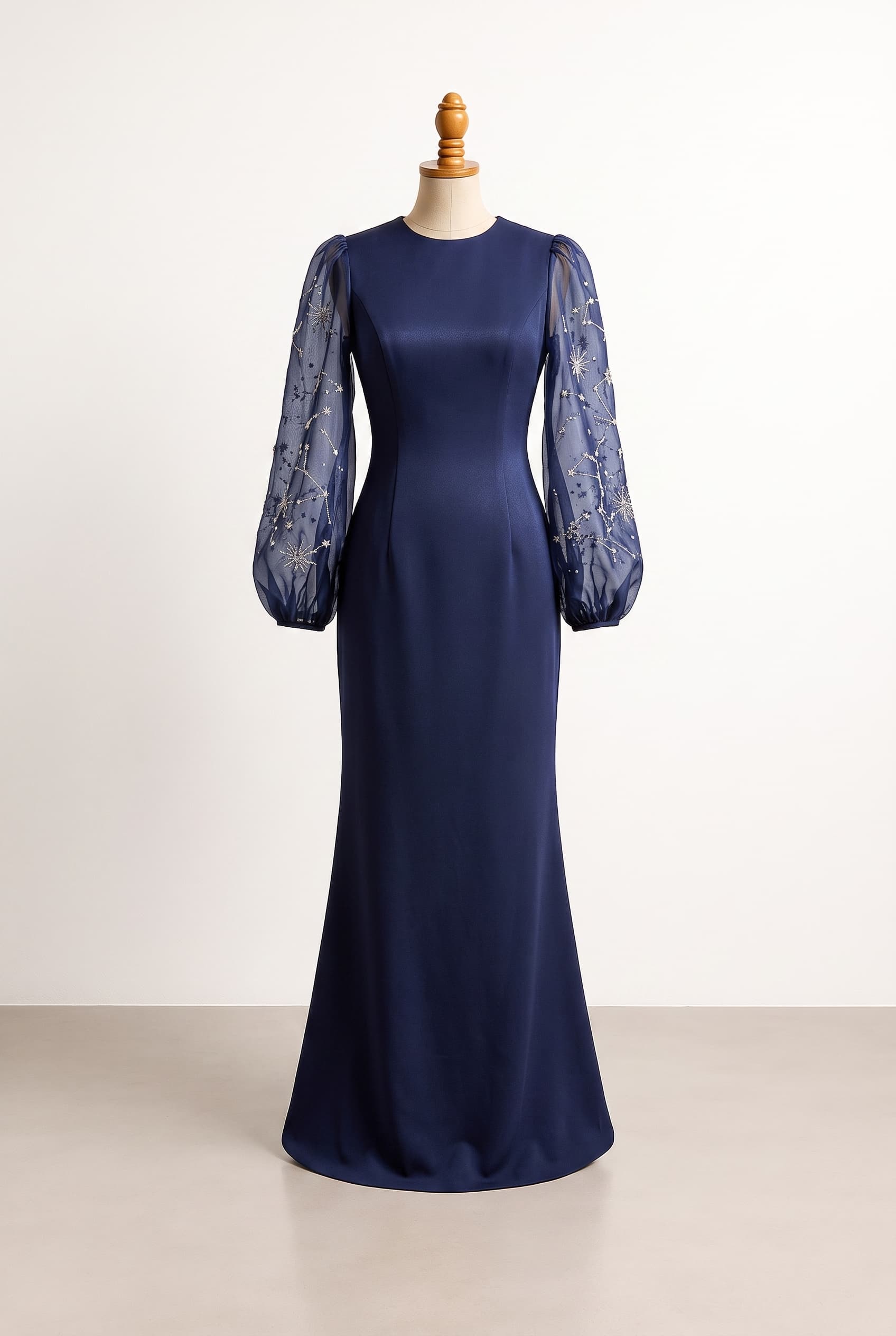 A structured indigo crepe gown with long, sheer bishop sleeves adorned with delicate constellation beadwork and silver embroidery; Review the attached front design image. Briefly describe what you see (color, silhouette, neckline, sleeves, length) and ask if the user wants changes or wants to move to back design