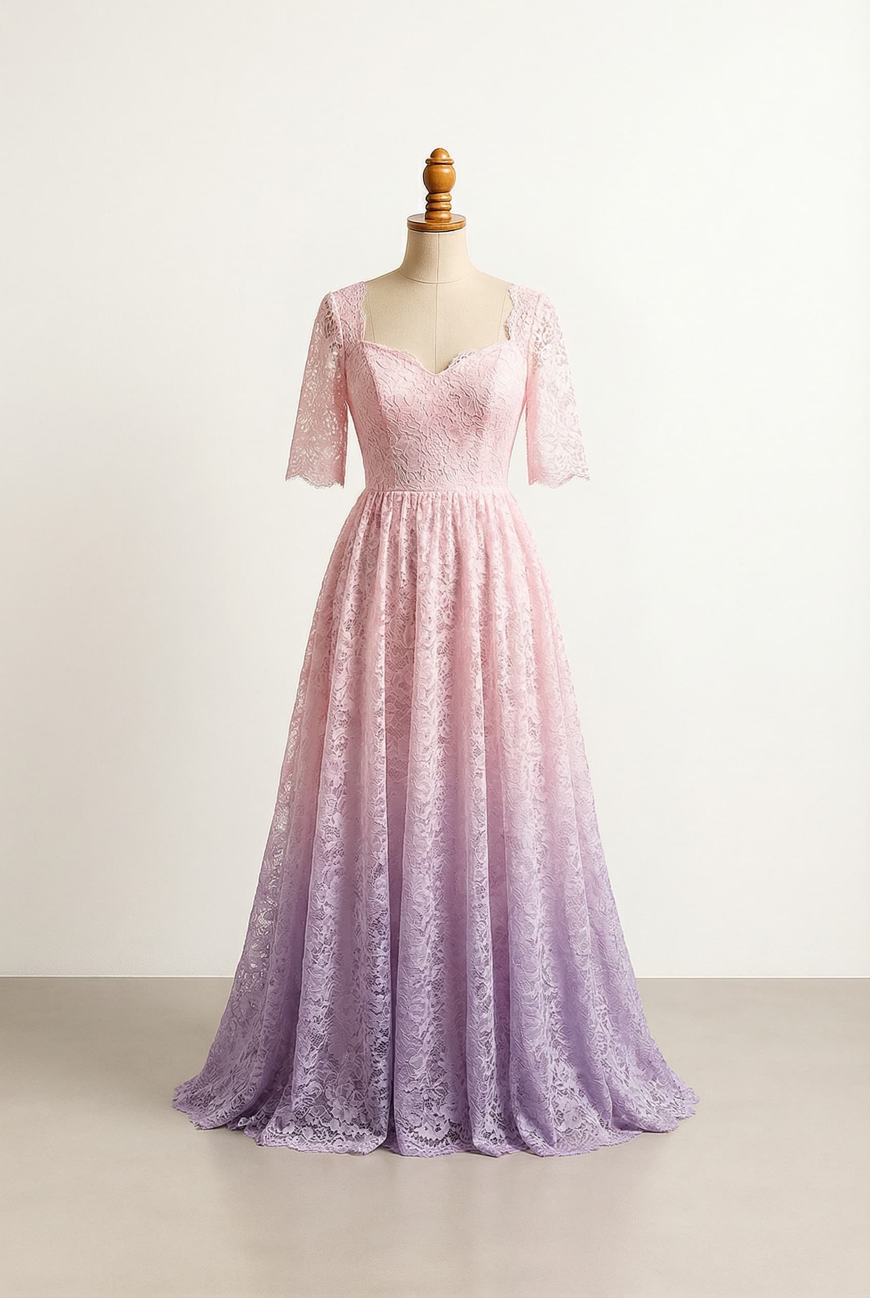 A romantic wedding dress with elegant details, with a soft pastel pink and purple ombré starting with pink and fading to purple, form fitting with a flowy overskirt, a floor-length hem, a sweetheart neckline, a dropped silhouette, and an elbow-length lace half jacket.