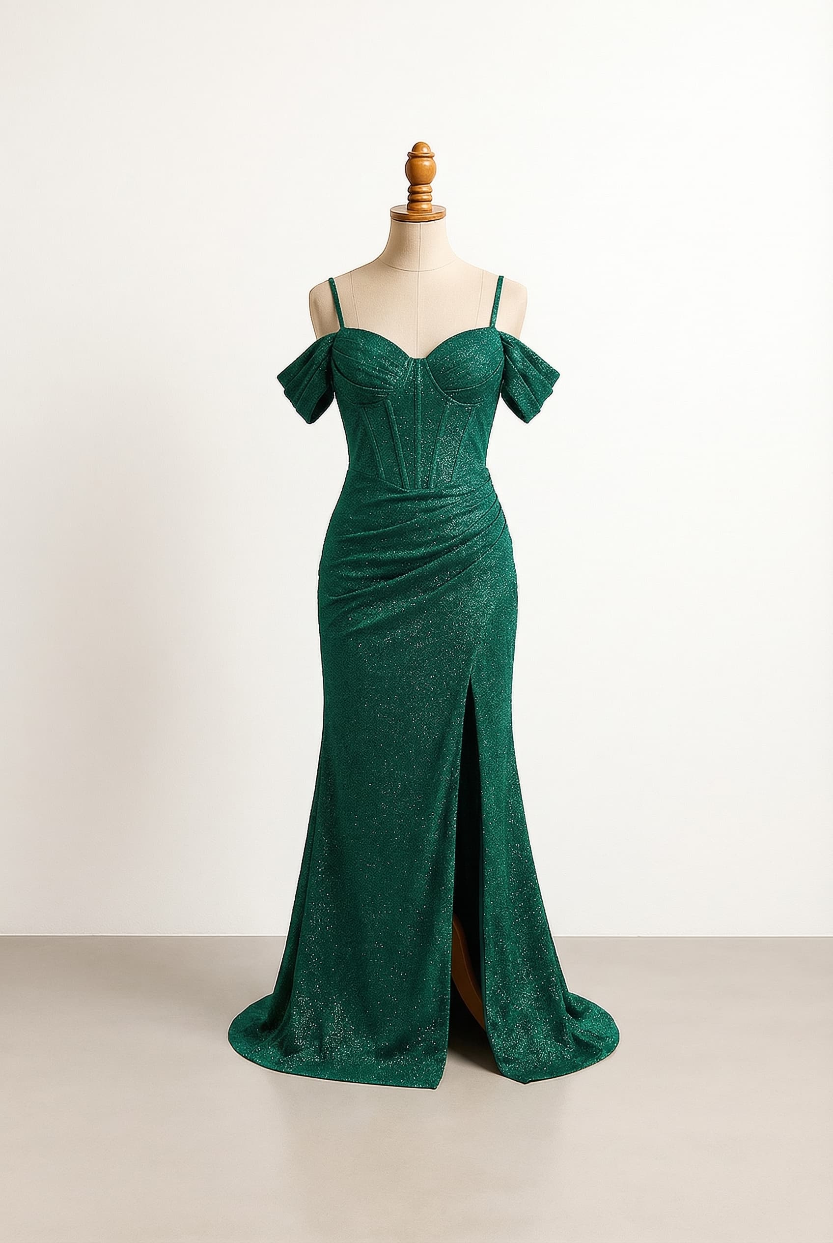 Emerald green evening gown with structured sweetheart corset bodice boning thin straps draped off-shoulder sleeves ruched waist fitted skirt with high slit floor-length hem with a curved sweetheart neckline and rounded beaded embellishments along the top edge with emerald rhinestone or crystal beads that continue up the thin shoulder straps and are decorated with matching emerald beads or rhinestones