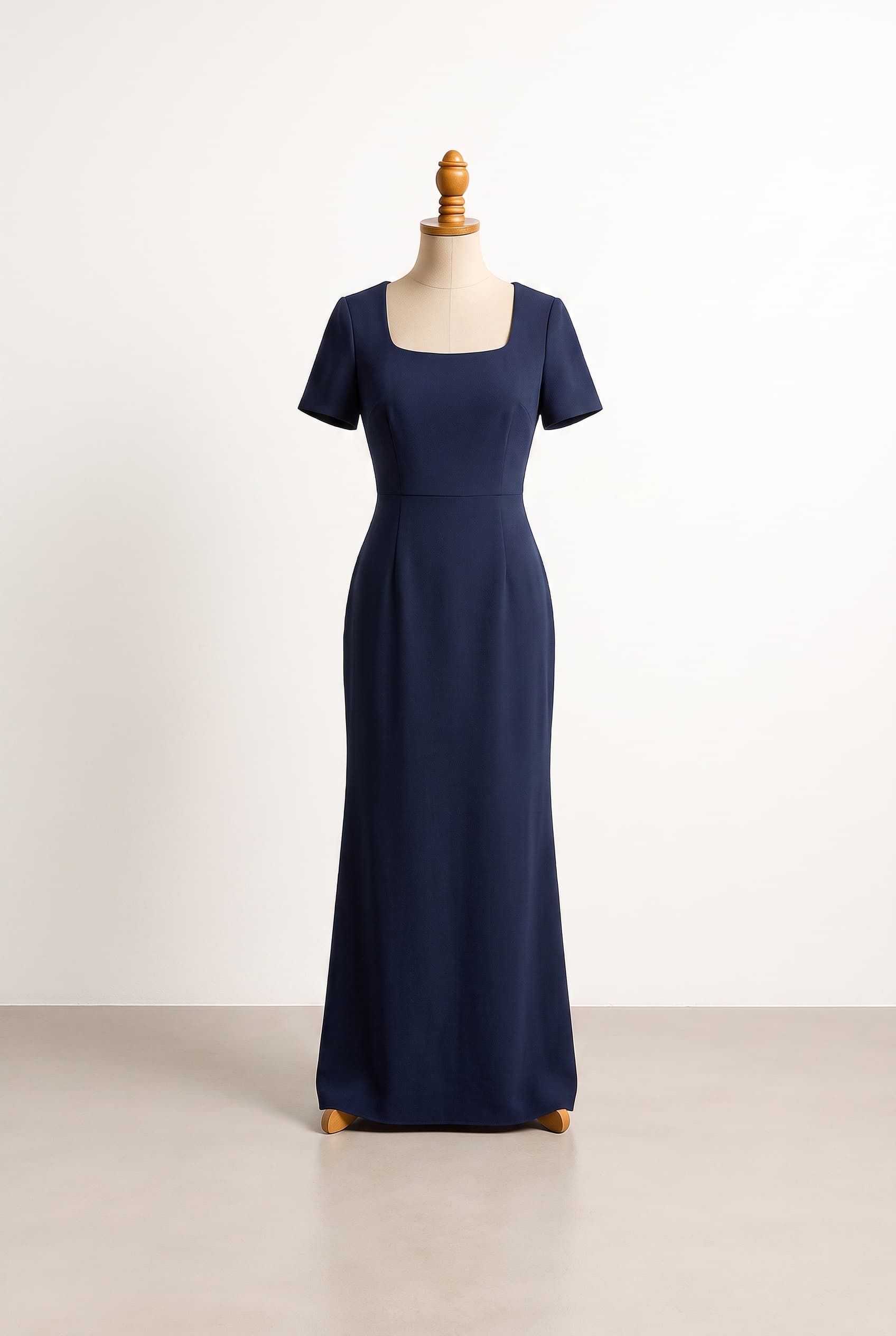 A balanced formal gown with a clean floor-length column silhouette, softly structured waist, elegant moderate coverage, and understated sophistication